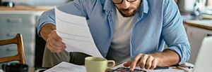 Person berechnet Finanzen mit Taschenrechner